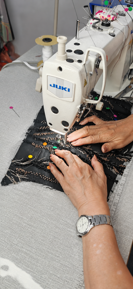 Kak Uji’s real hands carefully sewing intricate black lace with bronze beadwork and coloured pins